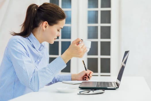 woman secretary in office working online on computer