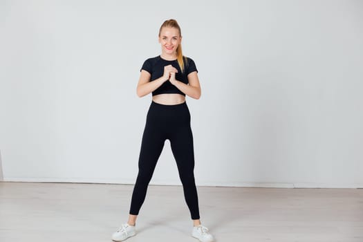 a woman in black tracksuit exercise sport in the gym warm-up exercises