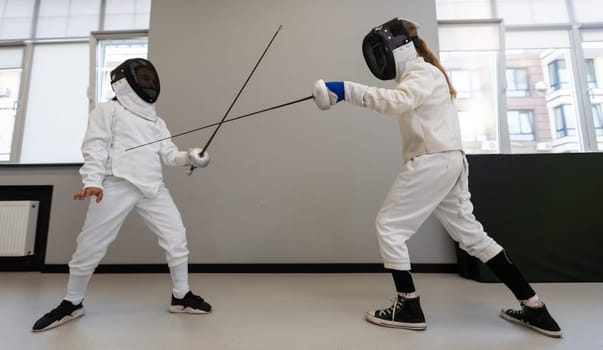 Children lunge on swords. A child in a class at a fencing school. High quality photo