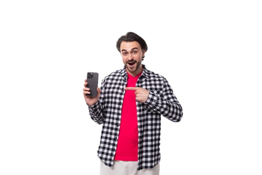 young european man with black hair and beard holding smartphone with screen mockup isolated on white background with copy space.