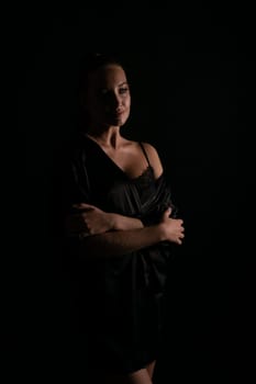 a woman in a black nightgown stands in the background in the shade
