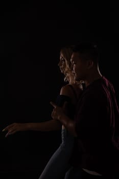 a man and a woman in love dance in dark hall