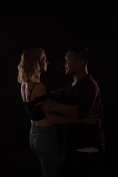 a man and a woman in love dance in dark hall
