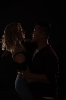 a man and a woman in love dance in dark hall