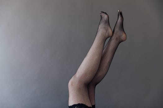 a beautiful slender women's legs in stockings in a net