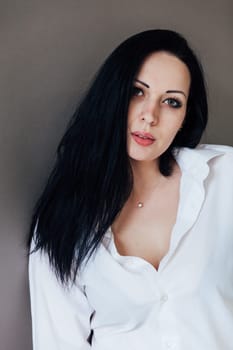 portrait of brunette woman with green eyes in a white shirt