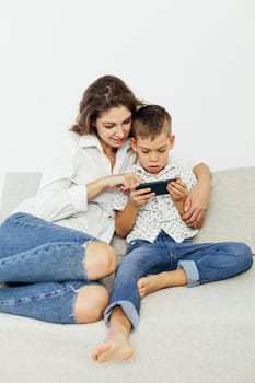 the child plays in the smartphone and the mother look