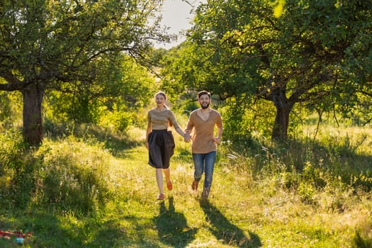 young couple walking in nature at sunset