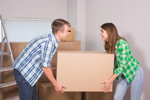 Happy young couple unpacking or packing boxes and moving into a new home