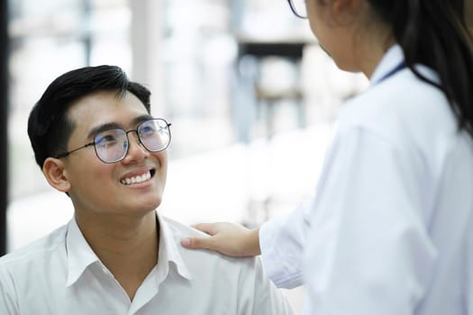 A happy young is smiling while his doctor is support him.