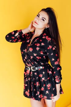 fashionable brunette woman posing on yellow background