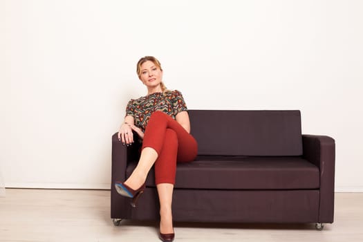 woman sits in a room on a soft sofa