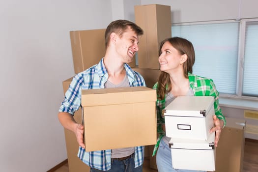 home, people, moving and real estate concept - happy couple with cardboard boxes at new home.