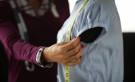 Female fashion designer arm making new dress closeup