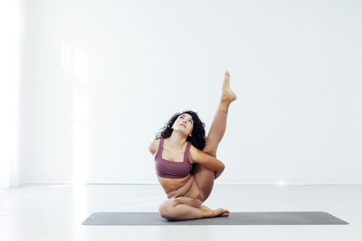 a woman doing yoga acrobat gymnast exercises for weight loss flexibility of the body