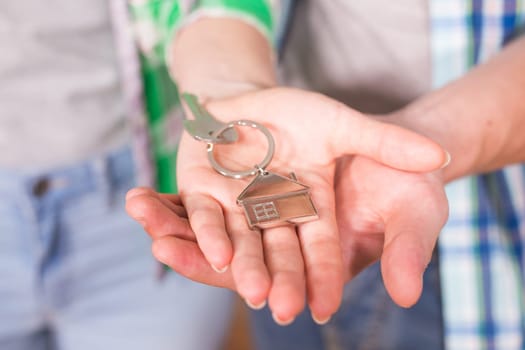Holding house keys on house shaped keychain in a new home