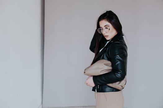 a woman brunette in sunglasses with beige women's bag