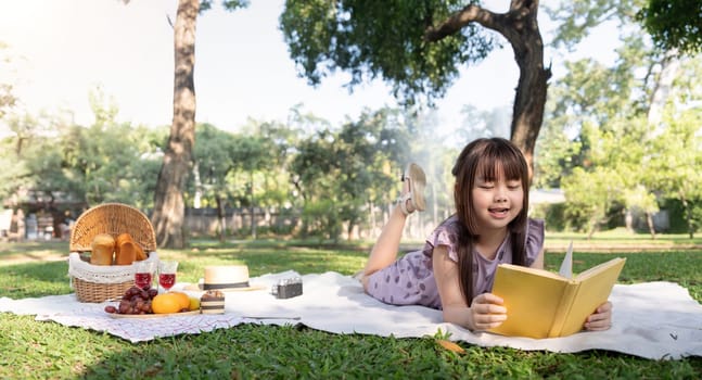 Cute little girl asian read book in park.