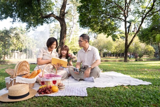 Happy senior grandparent together playing with little grandchild girl and party in park. Family leisure concept.