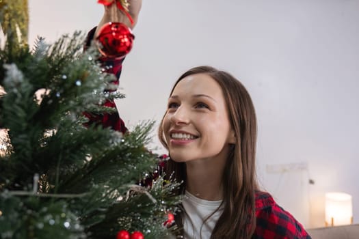 Mother and daughter are excited and happy to decorate the Christmas tree at home during the holiday season. Spending time together at Christmas.