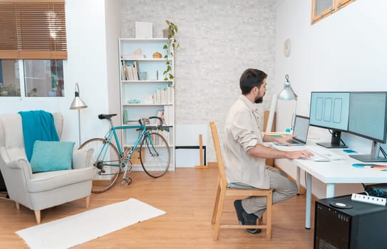 Young man working on computer from home apartment. High quality photo