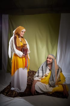 A couple in love or a married couple in stylized Eastern clothing from Israel, Palestine, Iran, Pakistan together. Tender photo session in the style of the Middle East and the Bible