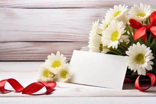 A bouquet of white daisies and a gift box on a table with red satin ribbons, a sheet of notes and red hearts on a light background. Gift for Valentine's Day