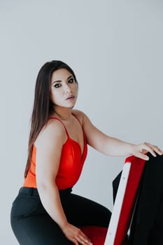 woman in red sits on a chair in the office office