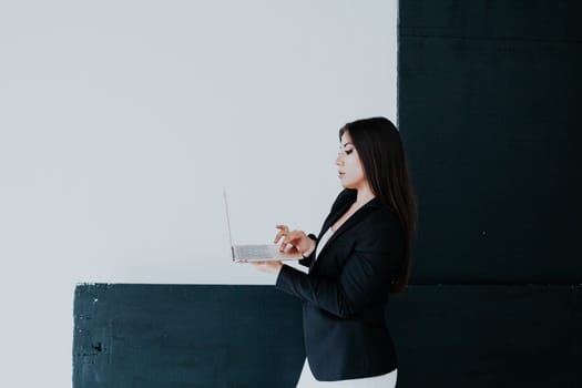 business woman in a black jacket holds a laptop in her hands