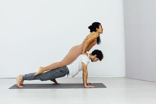 acrobatics woman stretches her back on a man training yoga classes in the vipassana hall