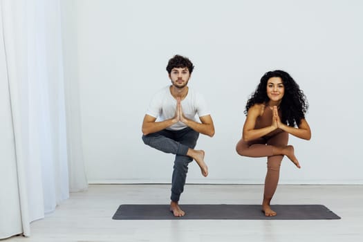 a man and woman engage in yoga training aerobics stretching
