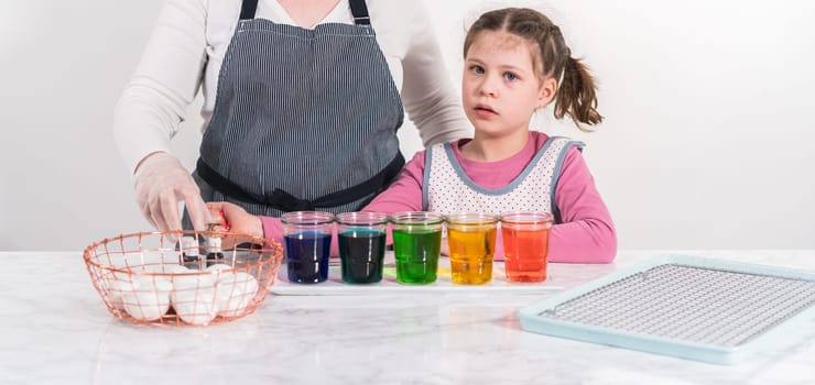 Easter egg coloring. Mixing food coloring with water and a dash of white vinegar to dye Easter eggs.