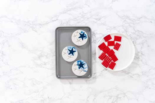 Flat lay. Filling silicone mold with red and blue melted chocolate to make chocolate stars for patriotic lemon cupcakes.