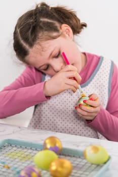 Easter egg coloring. Painting Easter eggs with gold luster.