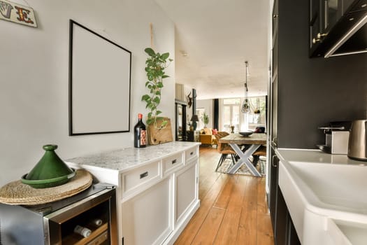 a kitchen and dining area in a house with wood floors, white cabinets, black walls and wooden flooring