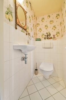 a small bathroom with floral wallpaper on the walls and white tile flooring in front of the toilet bowl