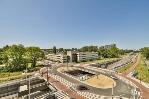 a city with buildings, roads and cars on the street in front of an overpassing area that is clear blue sky