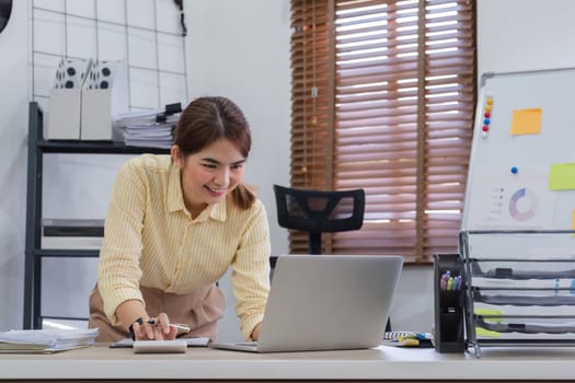 Businesswoman uses calculator to calculate finances, mathematics on table in office and business charts, tax, accounting, statistics and analytical research concept..