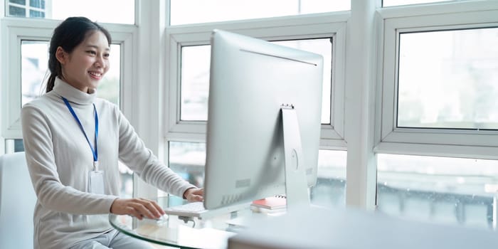 Businesswoman employee or freelance use computer to working on desk window in office.