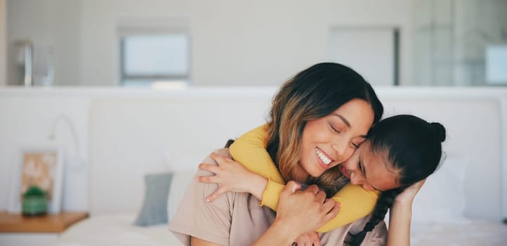 Love, hug and a mother hugging her daughter in the bedroom of their home in the morning together. Face, smile and a happy young girl embracing her single parent while on a bed in their apartment.