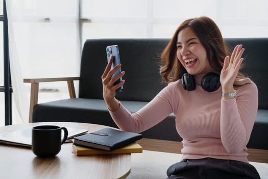 Happy girl checking social media holding smartphone sitting at sofa in living room at home. relaxing concepts