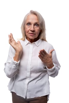 An elderly suspicious woman with gray hair looks carefully at the camera.