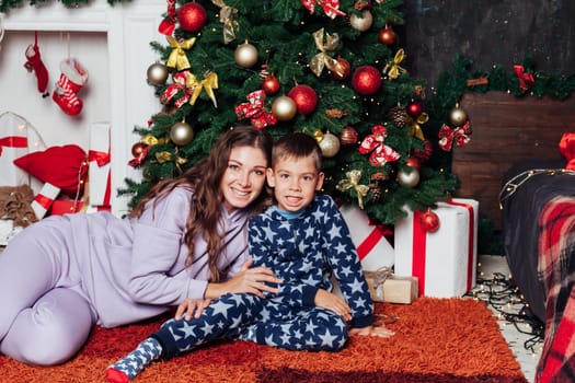 Mom with son at christmas tree for new year