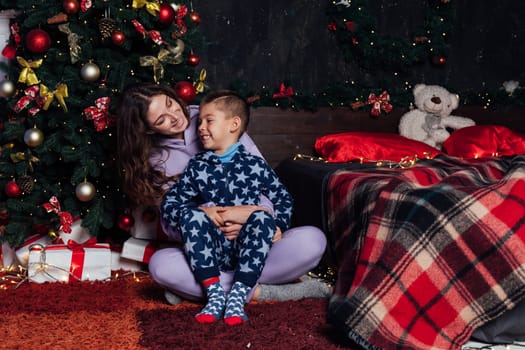 Mom with son at christmas tree for new year