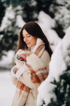 Portrait of a girl with long hair in mittens in a winter forest . Snowy winter.