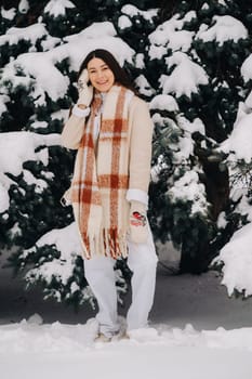 Portrait of a girl with long hair in mittens in a winter forest . Snowy winter.