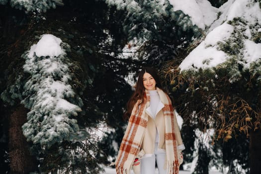 Portrait of a girl with long hair in mittens in a winter forest . Snowy winter.