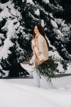 A girl in a winter forest with a bouquet of fir branches. Snowy winter.