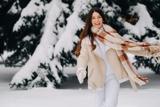 A girl in a winter forest with a bouquet of fir branches. Snowy winter.