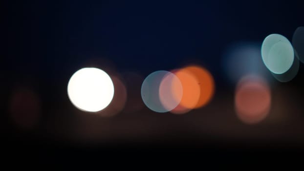 Blurred lights evening city traffic bokeh. Defocused night city traffic. Blurred lights bokeh car headlights driving evening city road. City night traffic background.